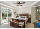 Main bedroom with king-size bed, sliding doors to a patio, and ensuite bathroom at 9277 Sw 70Th Loop, Ocala, FL 34481