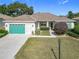 Single story home with green garage door and landscaped yard at 9397 Se 124Th Pl, Summerfield, FL 34491