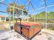 Enclosed hot tub with wooden cabinetry and safety rail at 9397 Se 124Th Pl, Summerfield, FL 34491