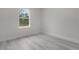 Bright bedroom with wood-look floors and large window at 1 Malauka Pass Ct, Ocklawaha, FL 32179