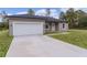 New home with attached garage and long concrete driveway at 1 Malauka Pass Ct, Ocklawaha, FL 32179