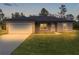 Newly built home with gray exterior, white garage door, and landscaped lawn at 1 Malauka Pass Ct, Ocklawaha, FL 32179