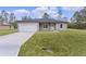 Modern house exterior with gray siding and white garage door at 1 Malauka Pass Ct, Ocklawaha, FL 32179