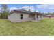 Rear view of house showcasing gray siding and covered patio at 1 Malauka Pass Ct, Ocklawaha, FL 32179