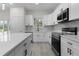 Bright kitchen featuring white cabinets, stainless steel appliances, and an island at 1 Malauka Pass Ct, Ocklawaha, FL 32179