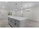 Modern kitchen island with white cabinets and quartz countertops at 1 Malauka Pass Ct, Ocklawaha, FL 32179