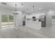 Open plan kitchen and dining area, showcasing modern appliances and light gray flooring at 1 Malauka Pass Ct, Ocklawaha, FL 32179