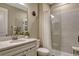 Bathroom featuring a walk-in shower, white vanity, and large mirror at 10161 Spring Lake Dr, Clermont, FL 34711