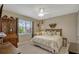 Bedroom featuring a queen bed, vintage furniture, large window, and neutral decor at 10161 Spring Lake Dr, Clermont, FL 34711