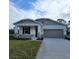 One-story home with gray siding, stone accents, and a two-car garage at 10161 Spring Lake Dr, Clermont, FL 34711