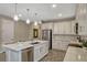 Bright, modern kitchen featuring a large island, white cabinetry, and stainless steel appliances at 10161 Spring Lake Dr, Clermont, FL 34711