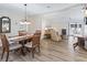 Bright dining room featuring a wooden table, four chairs, and hardwood floors at 1210 Tarpon Ln, The Villages, FL 32159