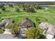 Stunning aerial view of home and golf course with mature trees and serene water feature at 12886 Se 97Th Terrace Rd, Summerfield, FL 34491