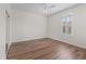 A bright empty bedroom features wood-look floors, ceiling fan and shuttered window at 12886 Se 97Th Terrace Rd, Summerfield, FL 34491