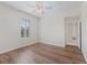 A bright empty bedroom features wood-look floors, ceiling fan and shuttered window at 12886 Se 97Th Terrace Rd, Summerfield, FL 34491