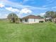 A beautiful backyard featuring lush green lawns, mature landscaping, and a screened-in lanai at 12886 Se 97Th Terrace Rd, Summerfield, FL 34491