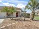 Inviting single-story home featuring a well-manicured front yard with beautiful palm trees at 12886 Se 97Th Terrace Rd, Summerfield, FL 34491