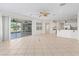 Bright, spacious living room with tile flooring leading to kitchen, natural light, and ceiling fan at 12886 Se 97Th Terrace Rd, Summerfield, FL 34491