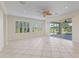 Bright, spacious living room featuring tile flooring, natural light, and a decorative ceiling fan at 12886 Se 97Th Terrace Rd, Summerfield, FL 34491