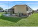 Exterior view of a tan mobile home and yard at 1303 E Schwartz Blvd, The Villages, FL 32159