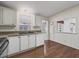 White kitchen cabinets, wood flooring and pass-through window at 1303 E Schwartz Blvd, The Villages, FL 32159