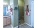 Bathroom featuring glass-enclosed shower and stylish vanity with granite countertops, enhanced by decorative accents and ample lighting at 1541 Fenimore Ln, The Villages, FL 32162