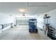 A clean, well-lit garage featuring a blue golf cart, organizational shelving, and a ladder at 1541 Fenimore Ln, The Villages, FL 32162