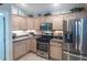 Well-lit kitchen featuring stainless steel appliances, light wood cabinets, and tile backsplash at 1541 Fenimore Ln, The Villages, FL 32162