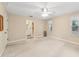 Bright bedroom with ceiling fan, carpet, and access to bathroom at 15831 Se 89Th Ter, Summerfield, FL 34491