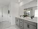 Double vanity bathroom with gray cabinets and marble floors at 16254 Ravenna Ct, Bella Collina, FL 34756