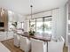 Bright dining room with wooden table, white chairs, and pool view at 16254 Ravenna Ct, Bella Collina, FL 34756