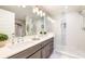 Bathroom featuring double sink vanity and glass enclosed walk-in shower with tile accents at 16300 County Road 455 # 414, Bella Collina, FL 34756