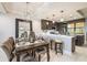 Dining room showcasing chandelier lighting, a dark wood table, and access to kitchen at 16300 County Road 455 # 414, Bella Collina, FL 34756