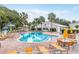 Resort-style community pool with plenty of lounge chairs and umbrellas at 16904 Se 110Th Court Rd, Summerfield, FL 34491