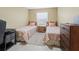 Bright bedroom with twin beds, dresser, and workspace at 16958 Se 94Th Sunnybrook Cir, The Villages, FL 32162