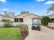 Cute one-story home with a golf cart and white picket fence at 16958 Se 94Th Sunnybrook Cir, The Villages, FL 32162