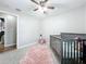 Bright bedroom featuring a crib and pink rug at 1805 Jefferson Dr, Mount Dora, FL 32757