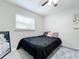 Simple bedroom with a black bedspread and window at 1805 Jefferson Dr, Mount Dora, FL 32757