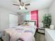 Cozy bedroom with a bed, nightstand, and pink curtains at 1805 Jefferson Dr, Mount Dora, FL 32757