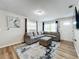 Living room with gray sectional sofa, ottoman, and wood-look floors at 1805 Jefferson Dr, Mount Dora, FL 32757