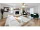 Living room with white sofa, green chairs, and a fireplace at 1805 Jefferson Dr, Mount Dora, FL 32757