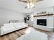 Living room features white sofa, fireplace, and wood floors at 1805 Jefferson Dr, Mount Dora, FL 32757