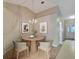 Charming dining area features a round table, four chairs, and tasteful wall art at 21524 Queen Anne Ct, Leesburg, FL 34748