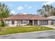 Single-story home with brown roof and landscaped lawn at 21524 Queen Anne Ct, Leesburg, FL 34748