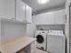 Laundry room with washer, dryer, and ample cabinet space at 21524 Queen Anne Ct, Leesburg, FL 34748