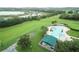 Aerial view of the community pool and gazebo area amidst lush green landscape and a lake at 2209 Stonebridge Way, Clermont, FL 34711