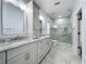 Modern bathroom with double sinks, granite countertops, and a glass-enclosed tiled shower at 2209 Stonebridge Way, Clermont, FL 34711