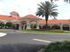 Community clubhouse with a red tile roof, inviting entrance, and manicured landscaping at 2209 Stonebridge Way, Clermont, FL 34711