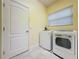 Functional laundry room with a side-by-side washer and dryer set, plus access door at 2209 Stonebridge Way, Clermont, FL 34711