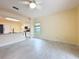 Open living area with tile floors showcasing the kitchen with granite counters and white cabinetry at 2209 Stonebridge Way, Clermont, FL 34711